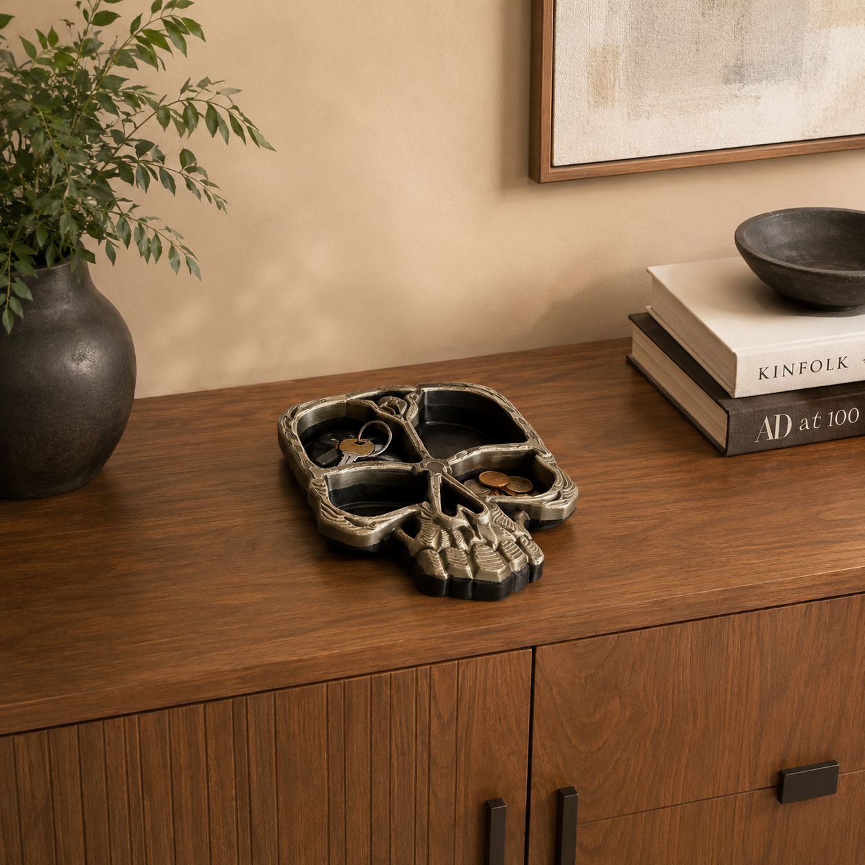 Skull tray organizer displayed on a wooden credenza with keys, coins, books, and modern home décor accents.