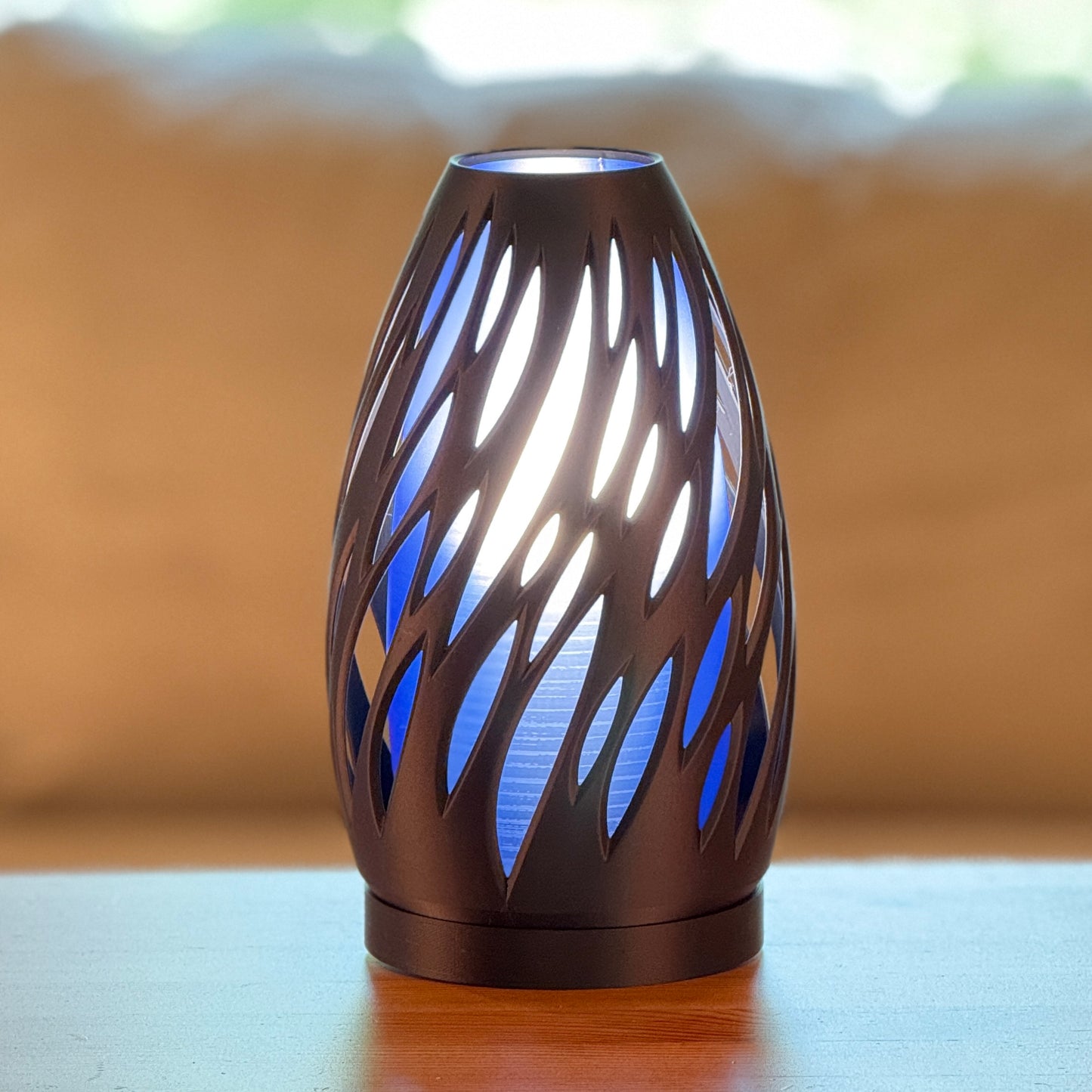 Spectra lamp casting warm and cool ambient light through organic cutouts