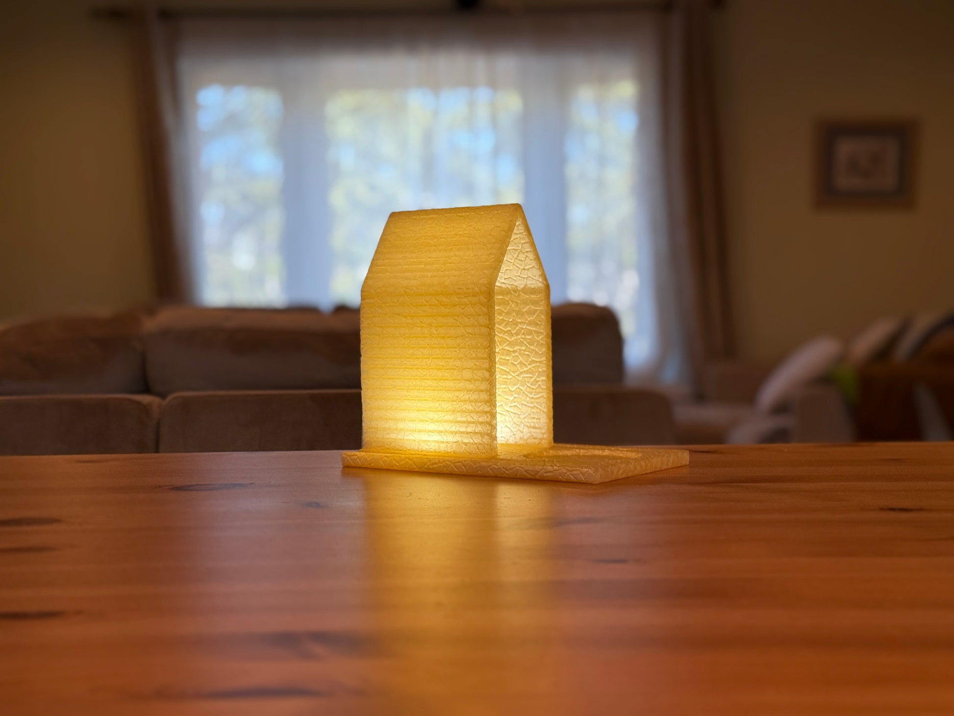 Modern table lamp shaped like stacked books casting a soft warm glow