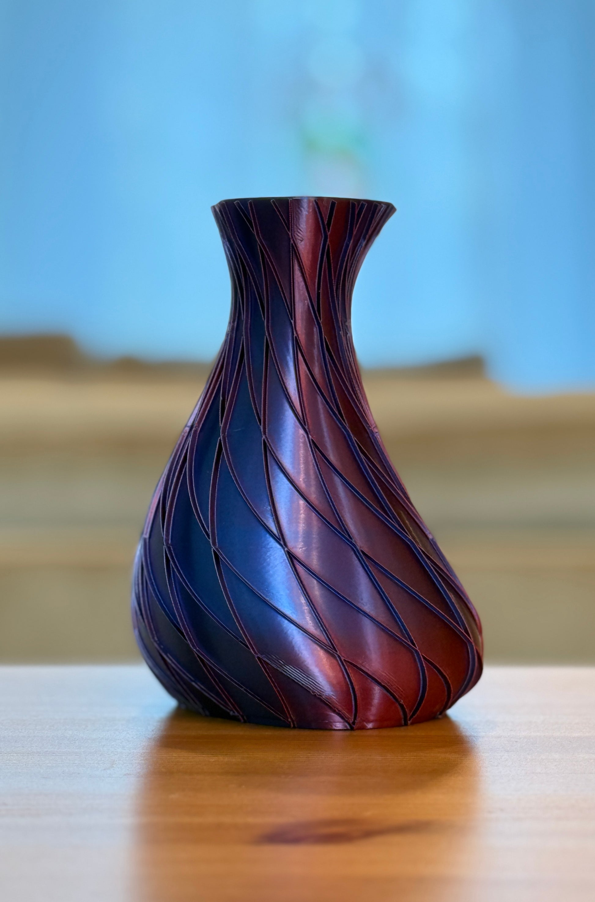 Decorative vase with wavy pattern on a wooden surface