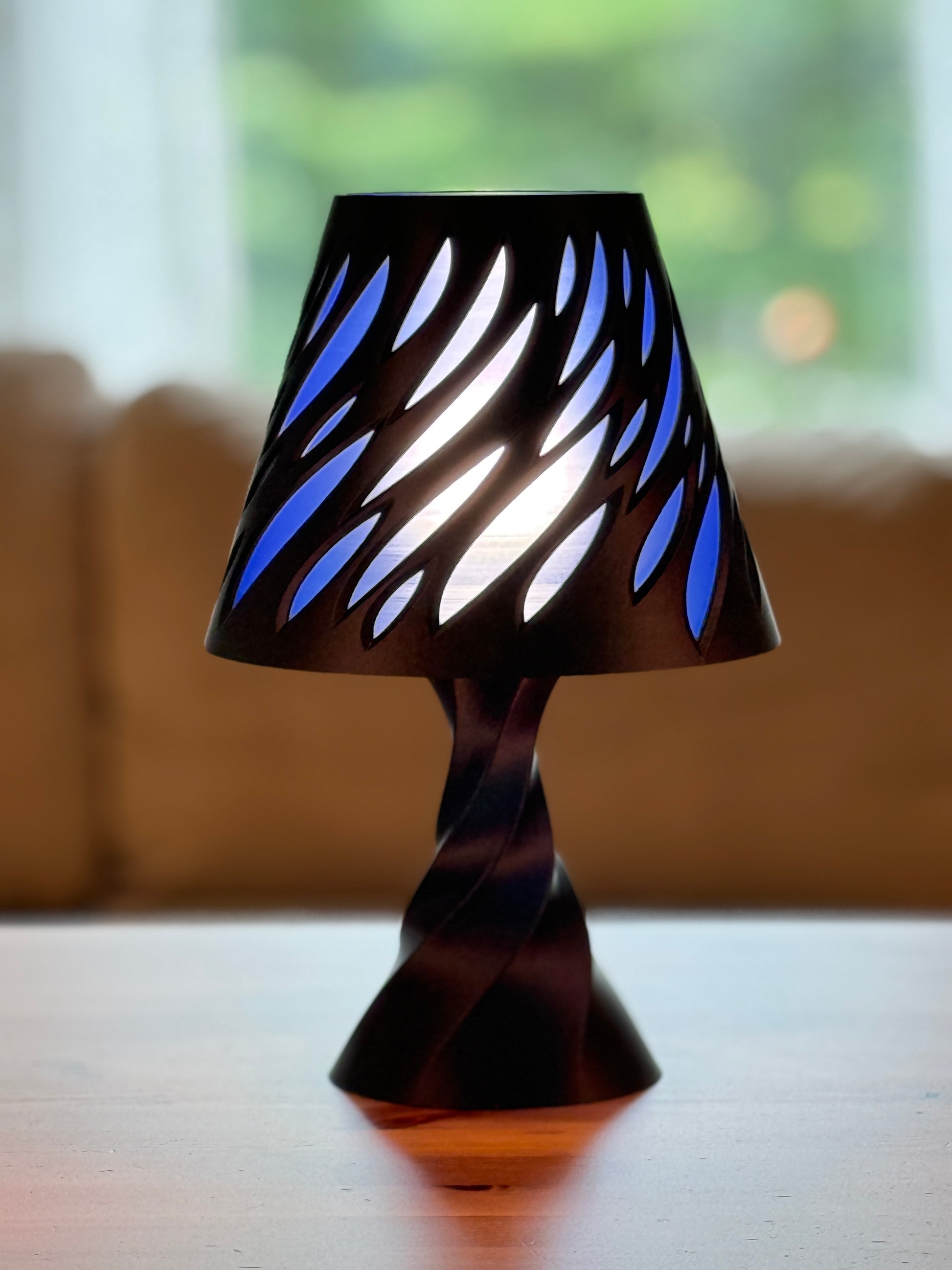 Tall Spectra Lamp illuminated on wooden table in modern interior setting